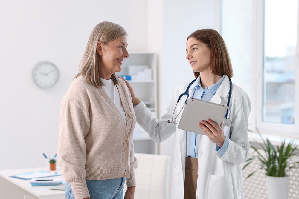 Identifying Risks / Testing - Yorkville Medical Associates Smiling healthcare worker with tablet supporting senior patient in hospital