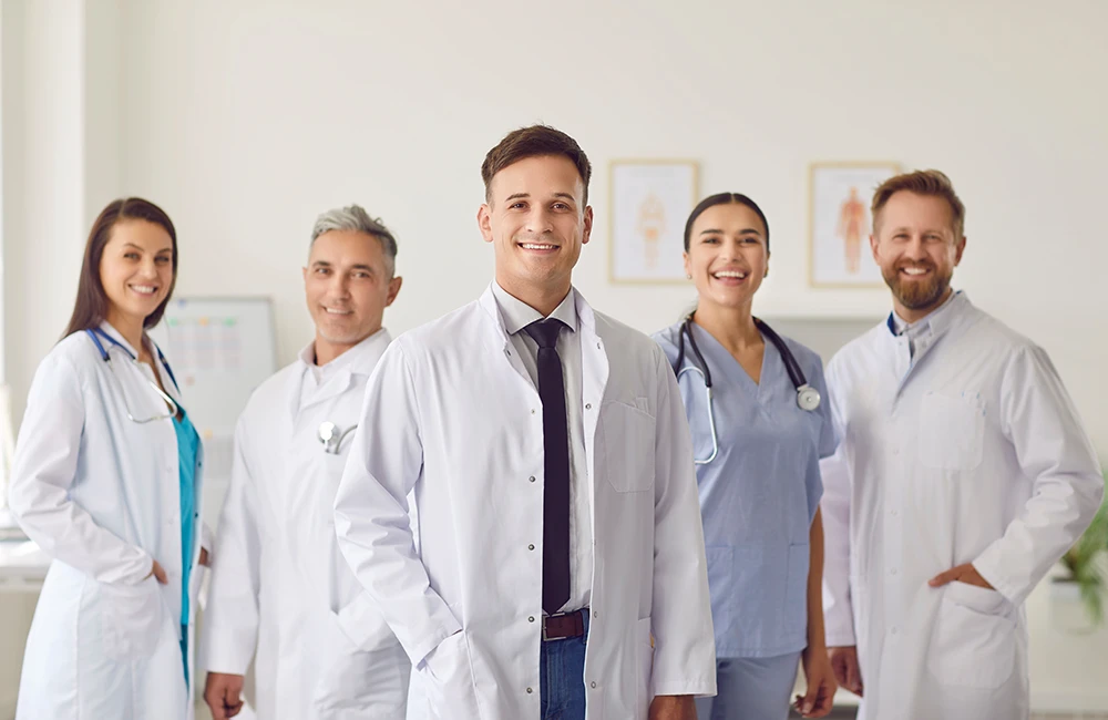 Portrait of a man doctor standing with a team of other doctors and nurses in the hospital